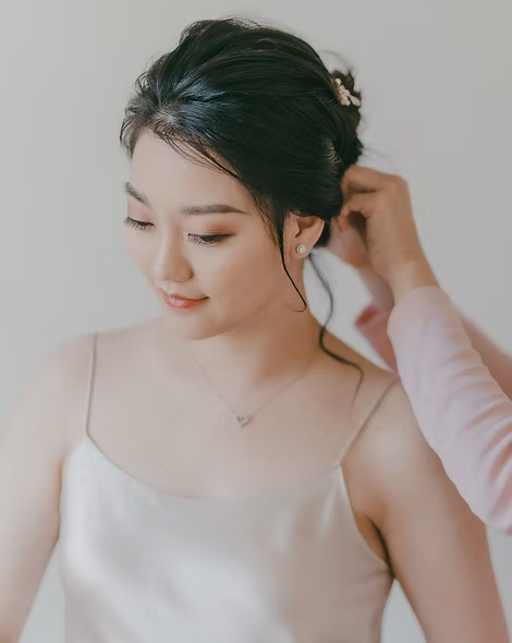 Bride having her earring adjusted before the ceremony